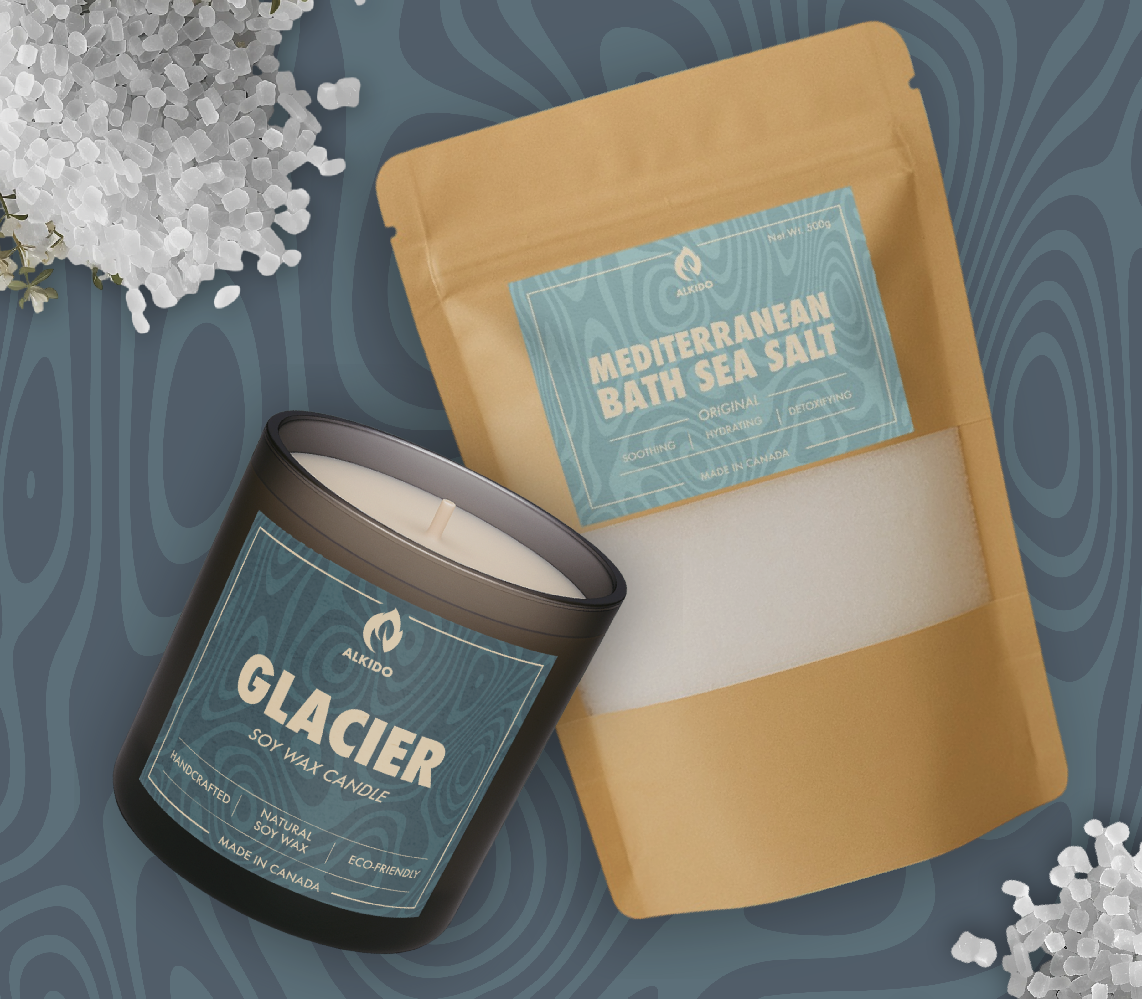 A candle and a bag of sea salt laying surrounded by salt crystals. 