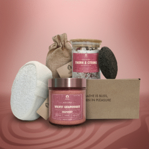 ALKIDO spa set featuring 'Velvet Grapefruit' grapefruit body scrub, 'Thorn & Citrine' Dead Sea salt spa mix, lavender sachet in a linen bag, natural loofah, black lava stone, and eco box, styled on a soft rose-toned background.