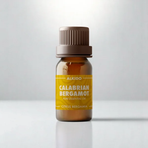 ALKIDO Calabrian bergamot pure essential oil in an amber glass bottle with a green label and brown cap on a light background