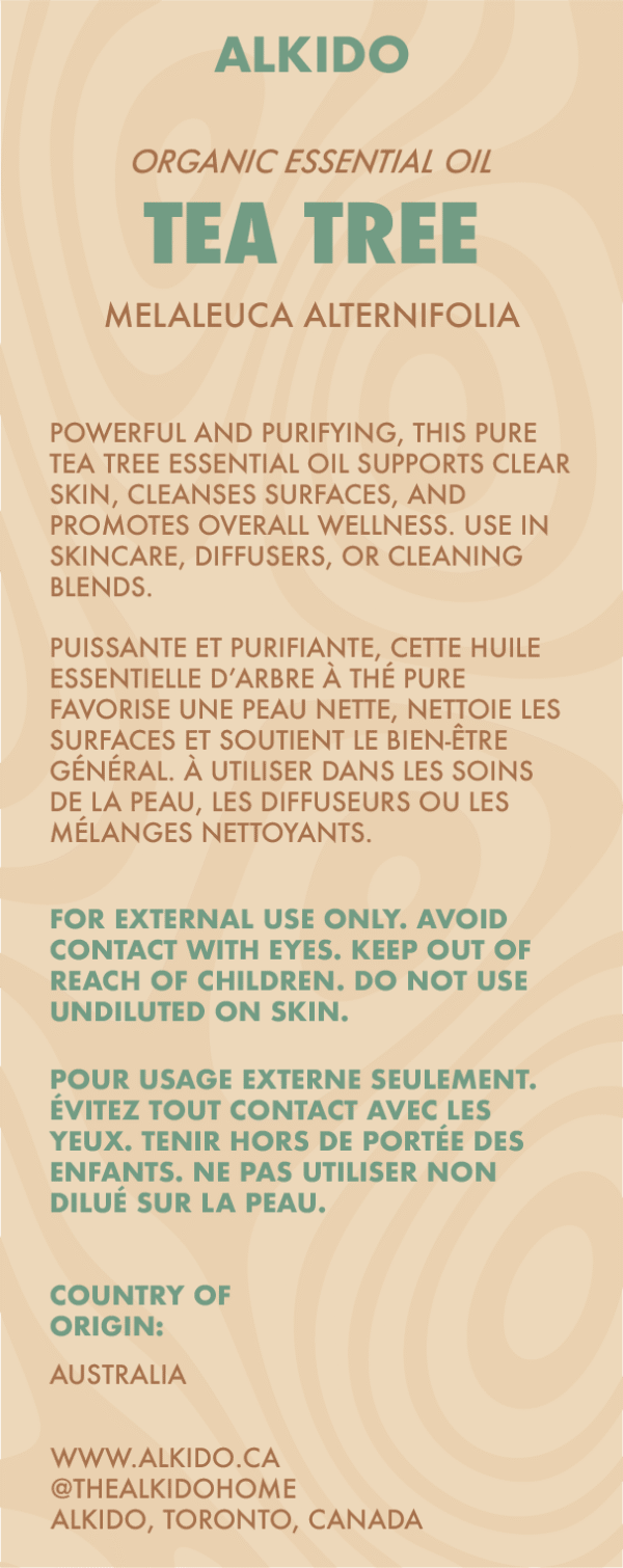 ALKIDO Tea Tree Organic Essential Oil label showing benefits for skincare and wellness, with bilingual safety warnings, botanical name (Melaleuca Alternifolia), and origin Australia. Natural wood-toned background with bold teal text.
