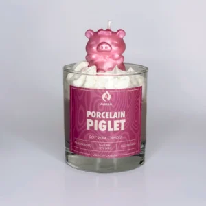 Decorative candle with a pig sitting on top and a pink label