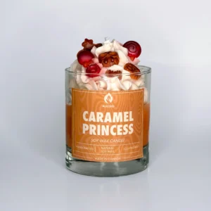 Decorative candle with sweets and candy decor sitting on top and an orange label