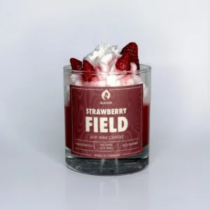 Decorative candle with strawberry decor on top and a red label